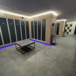 Edzőterem öltöző általános világítás a kis belmagasság miatt egyedien a szekrénysor tetejére felszerelve 45 fokos dőlésszögű profilt és nagy led sűrűségű szalagot használva meg kék hangulatvilágítás a talpazatba rejtve beszerelve
